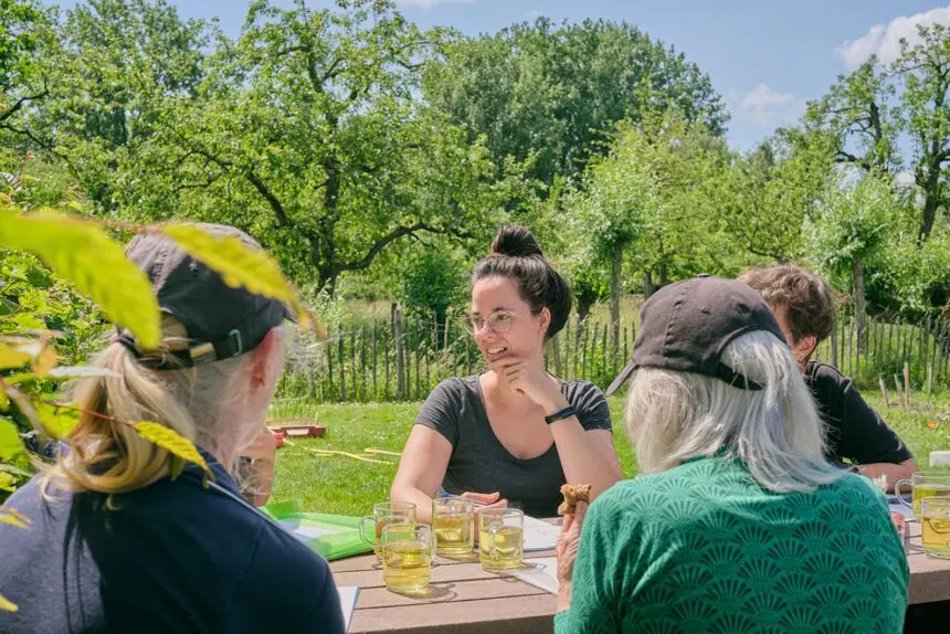 Personen aan tafel in de tuin bij stadsboerderij koppelsteede