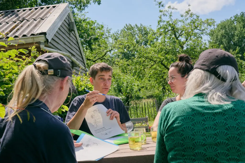 Moestuinexpert Mariken Heitman geeft een workshop aan tafel.